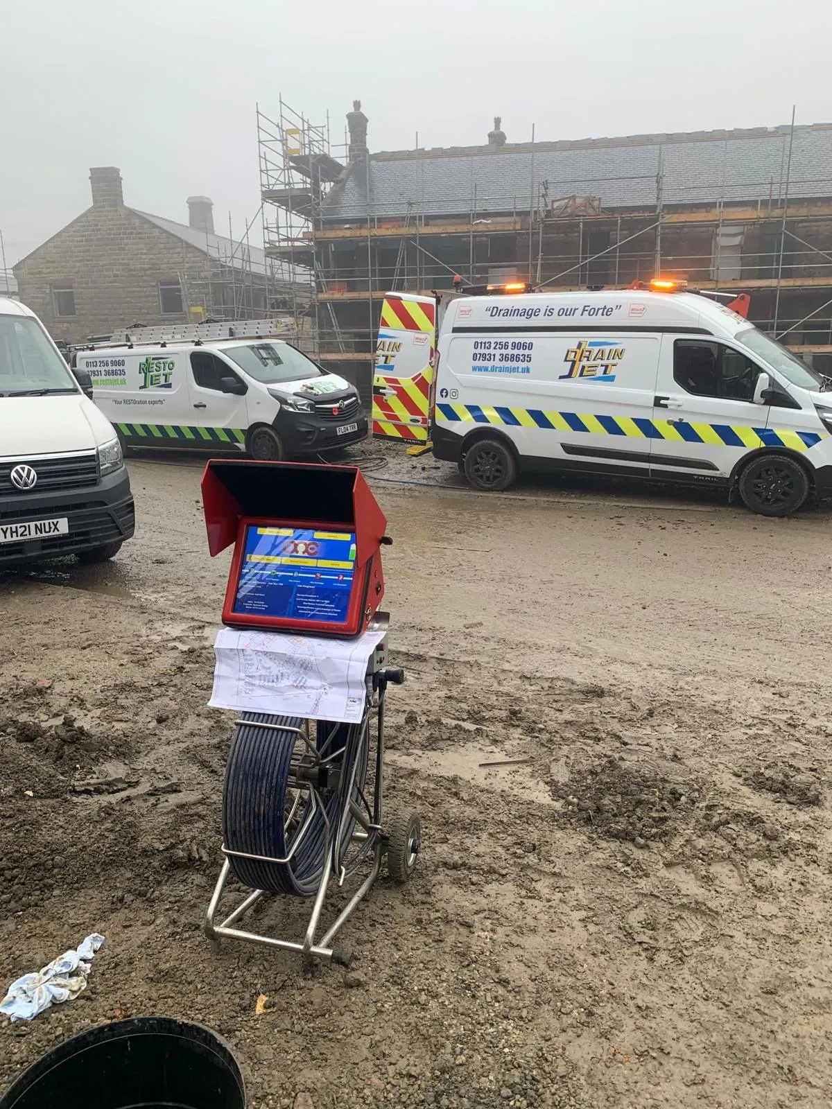 Professional CCTV drain survey equipment and Drain Jet service vehicles at a construction site in Leeds.